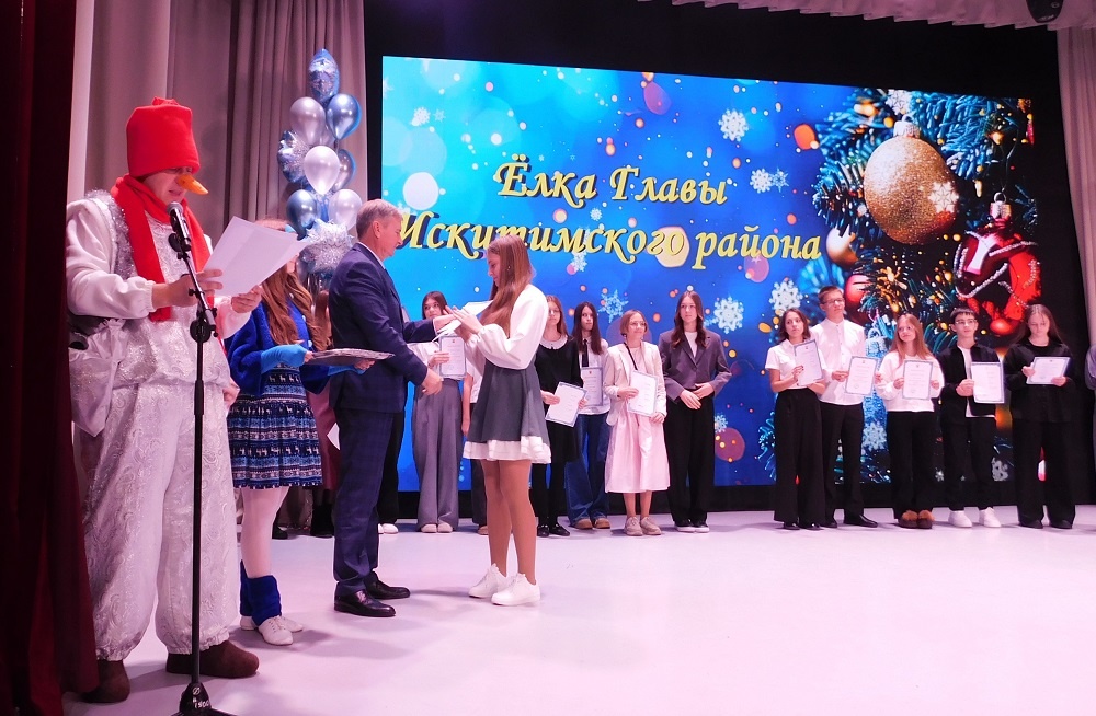    Глава Искитимского района Юрий Саблин вручает премии отличникам учебы. Фото Анны Зубаревой