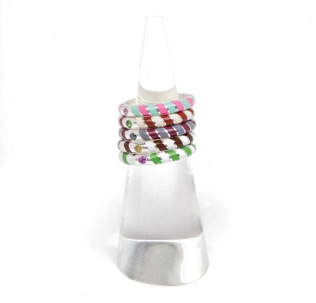 Лакированные кольца Memphis Candy от Alice Cicolini, созданные из серебра или золота, полученных в рамках программы Fairtrade, украшены яркими драгоценными камнями, включая розовые сапфиры, цавориты и голубые бриллианты.