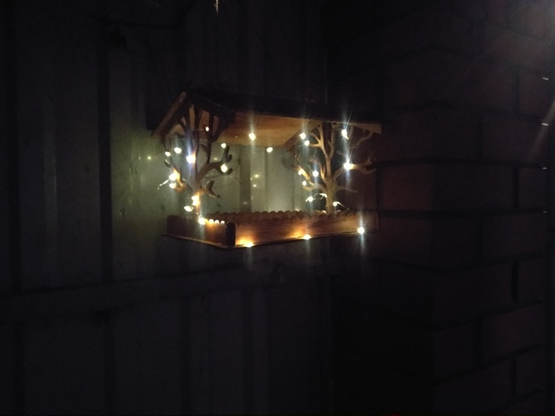 Кормушка, украшенная гирляндой