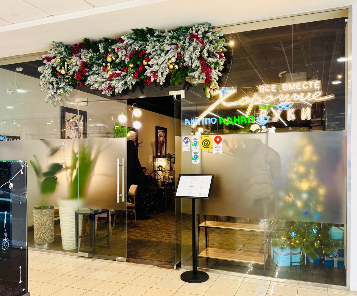 На входе сразу заметно новогоднее оформление, а внутри видна елочка с подарками