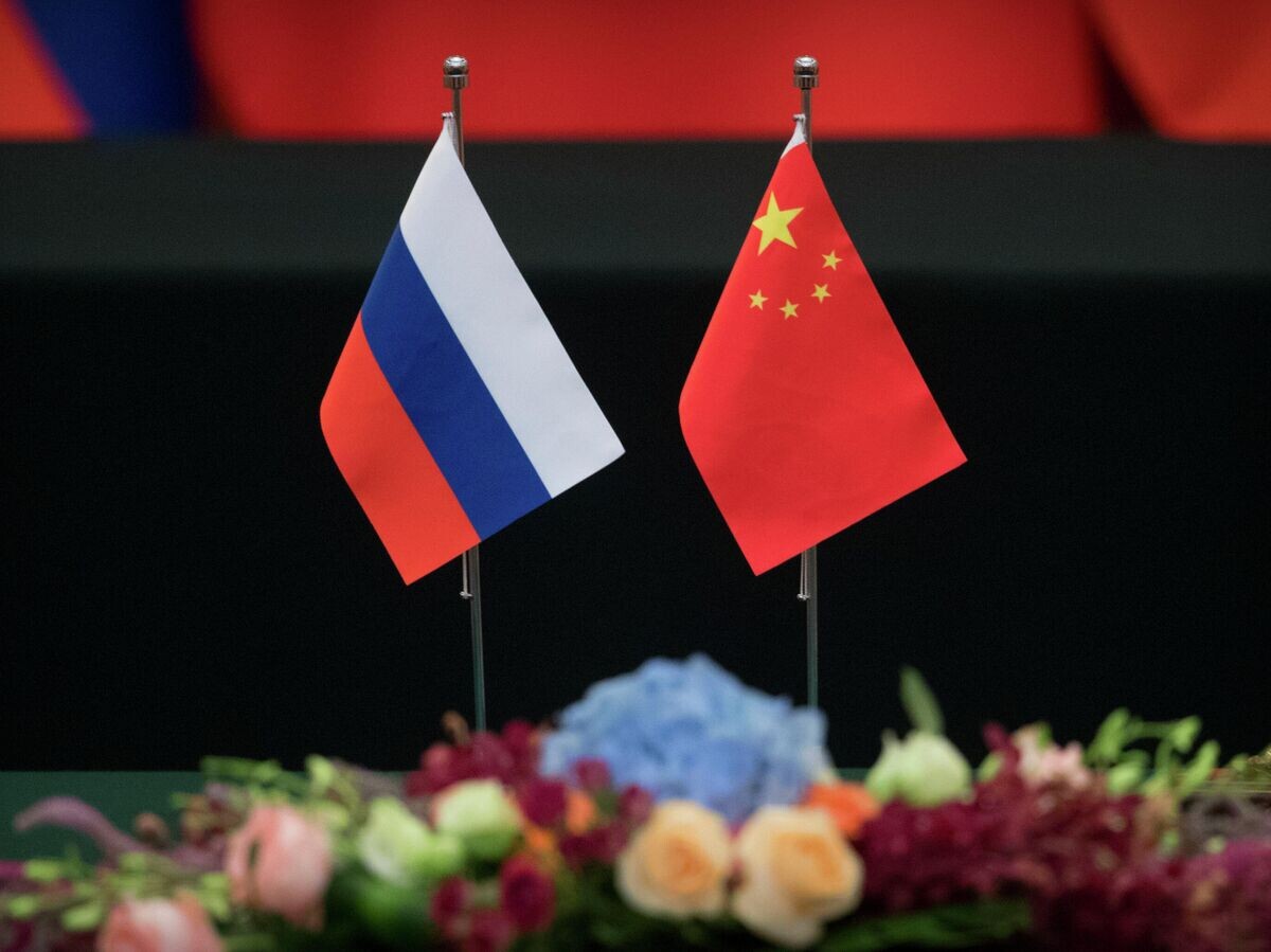    Государственные флаги России и Китая на столе в Доме народных собраний в Пекине | © AP Photo / Mark Schiefelbein