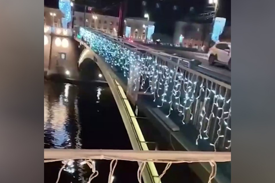    Мужчина починил новогоднюю подсветку на мосту в Петербурге. Фото: соцсети