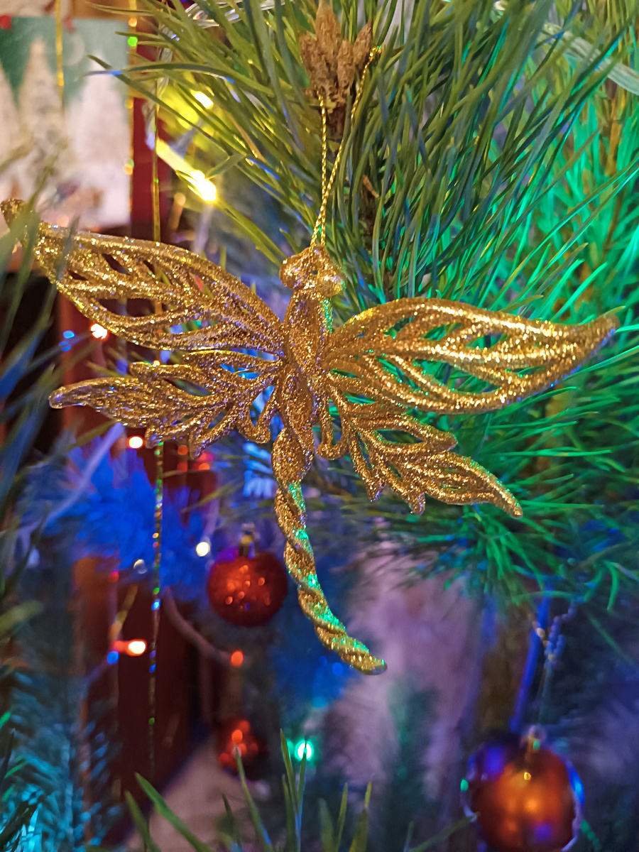 Красные шарики на ëлке разбавила блестящими золотистыми фигурками