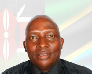 Photo – Taifa Leo library
Джон М. Кобиа (John M. Kobia) –  Доцент кафедры суахили в Университете Чука, расположенном в области Чука/Игамба-нгомбе округа Тарака-Нити, что примерно  в 186 км от Найроби по дороге Найроби-Меру, в сельской местности на восточных склонах горы Кения на высоте около 2000 метров над уровнем моря. 

