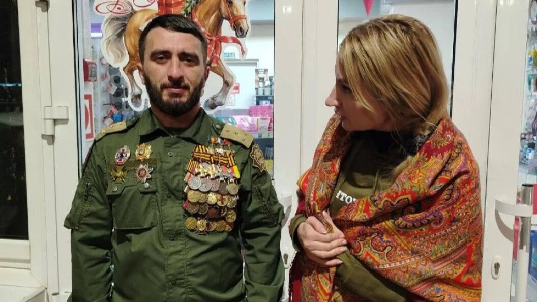    Екатерина Колотовкина разглядывает награды одного из ряженых Героев России. Фото: Телеграм-канал Екатерины Колотовкиной