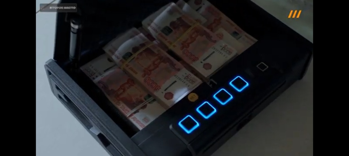 Чемодан с деньгами открывается перед семьей технолога. Купюры аккуратно уложены. Выглядит как сцена из гангстерского кино. Это визуализация власти: “Я могу решить любую проблему пачкой наличных”.