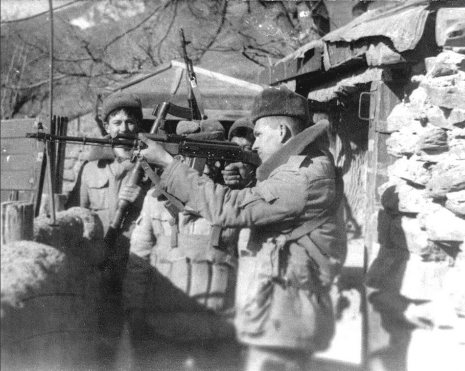 Руха, Панджшер, ноябрь 1986 года, заместитель командира взвода Евгений Баранов проверяет у личного состава оружие после чистки. Слева стоит командир БМ21 Михаил Бескровных, в центре механик-водитель Амантай Ахатаев, справа механик-водитель Зият Атамбаев.