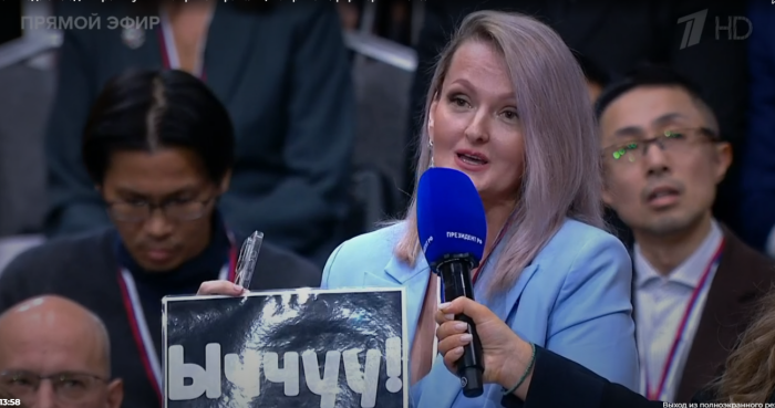 Журналистка из Якутии обратила внимание Владимира Путина на табличку, на которой на языке саха написано «Холодно» / Скриншот экрана эфира «Прямой линии»