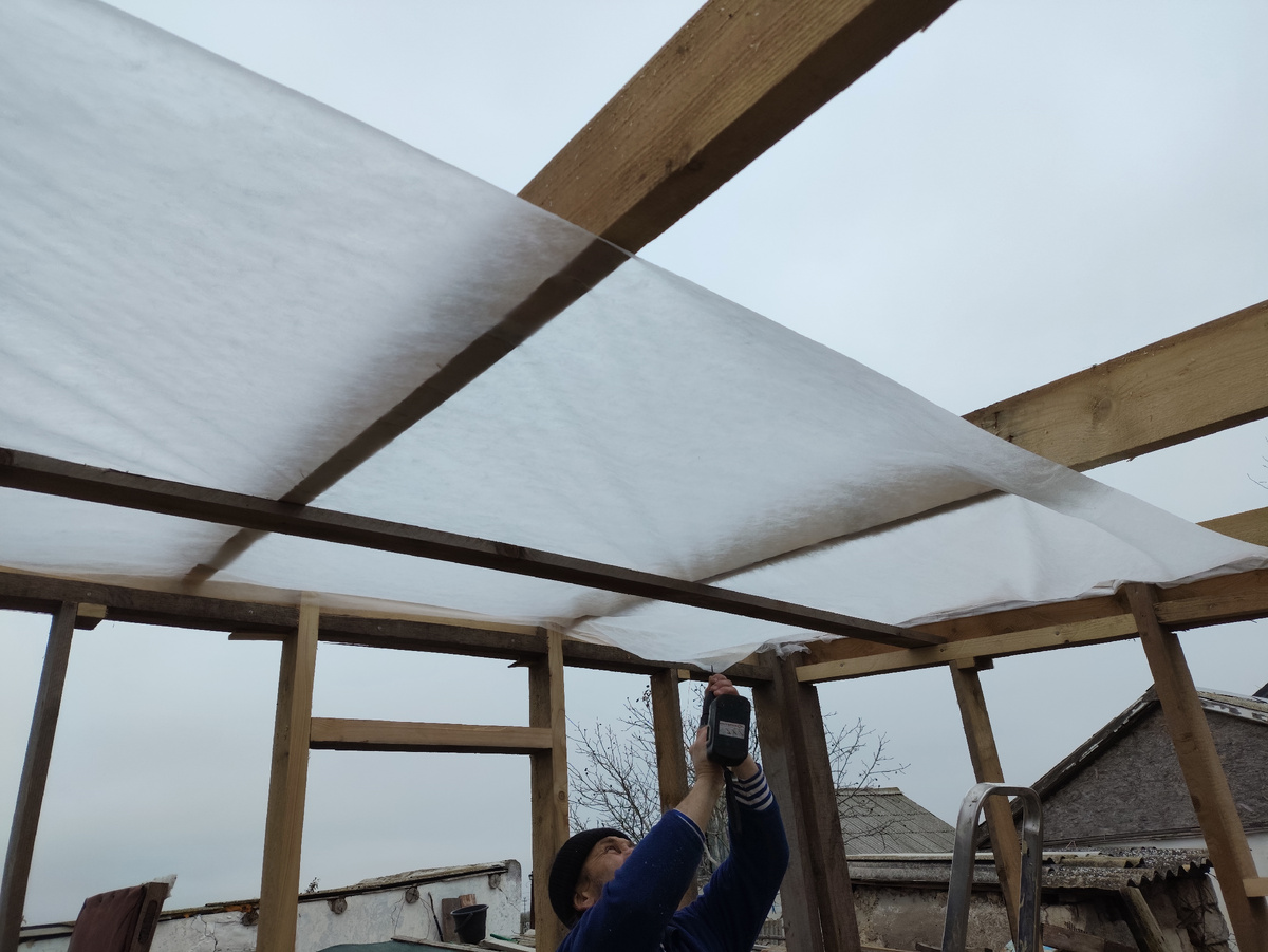 Первая полоса уложена.Олег ее сразу досочками крепит, потому как без всяческого прогноза неожиданный ветер налетел