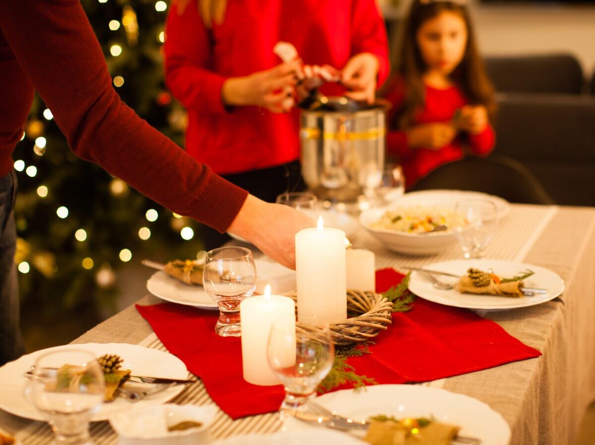    Люди украшают новогодний стол | © iStock.com / oksix