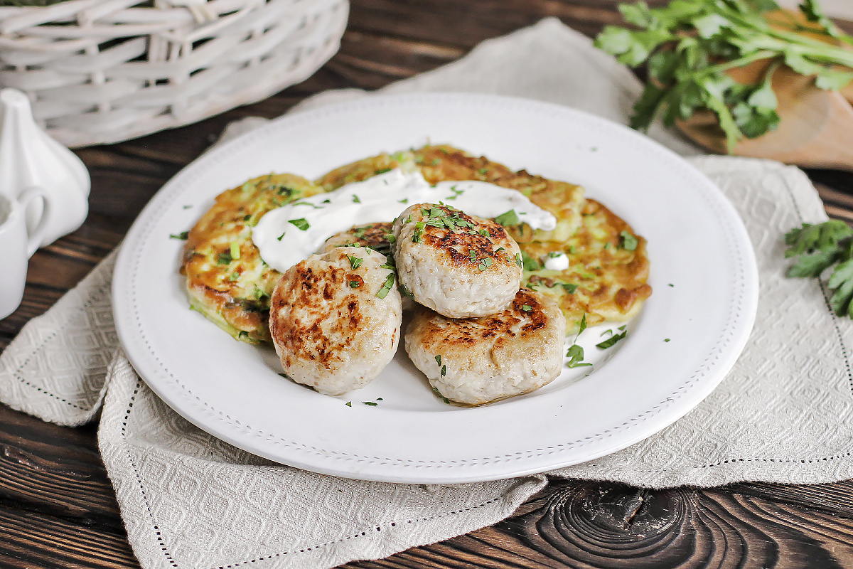 Куриные котлетки с кабачковыми оладьями, сметаной и зеленью