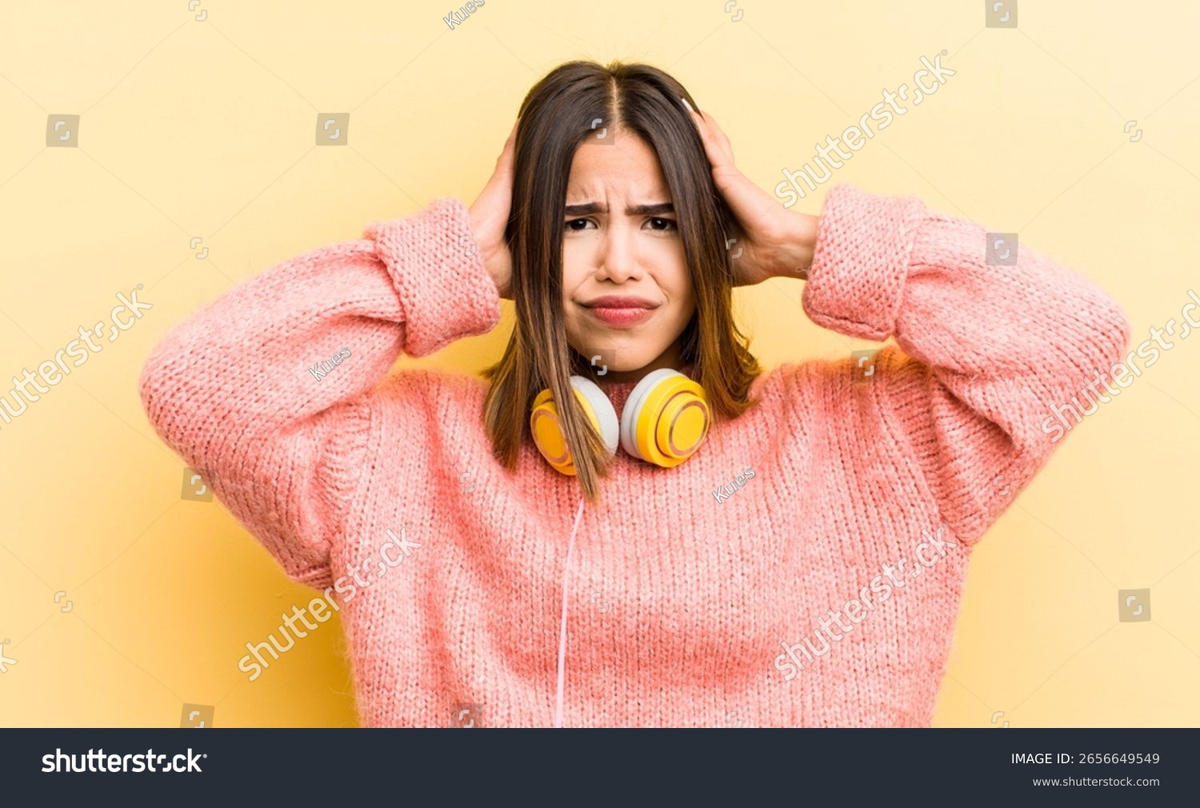 https://www.shutterstock.com/shutterstock/photos/2656649549/display_1500/stock-photo-pretty-hispanic-girl-feeling-stressed-anxious-or-scared-with-hands-on-head-headphones-concept-2656649549.jpg