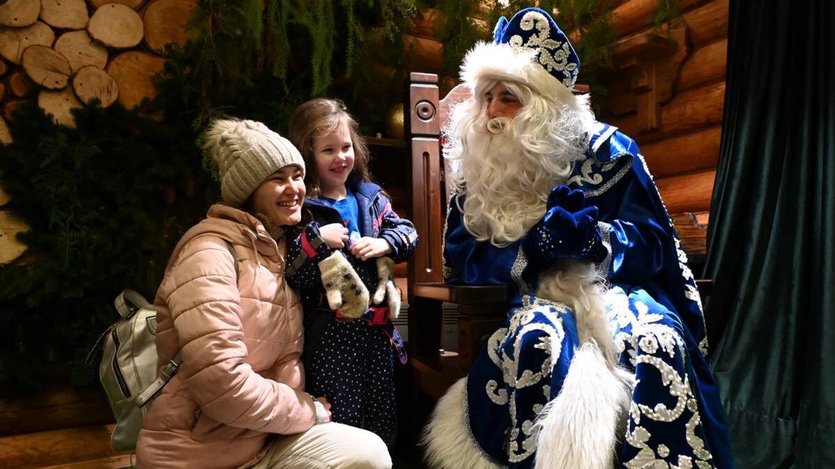    Московский Дед Мороз поздравляет с наступающим Новым годом четырехлетнюю москвичку Алису и ее маму Регину Мухамедзянову / Фото: Мария Хапцова / Вечерняя Москва