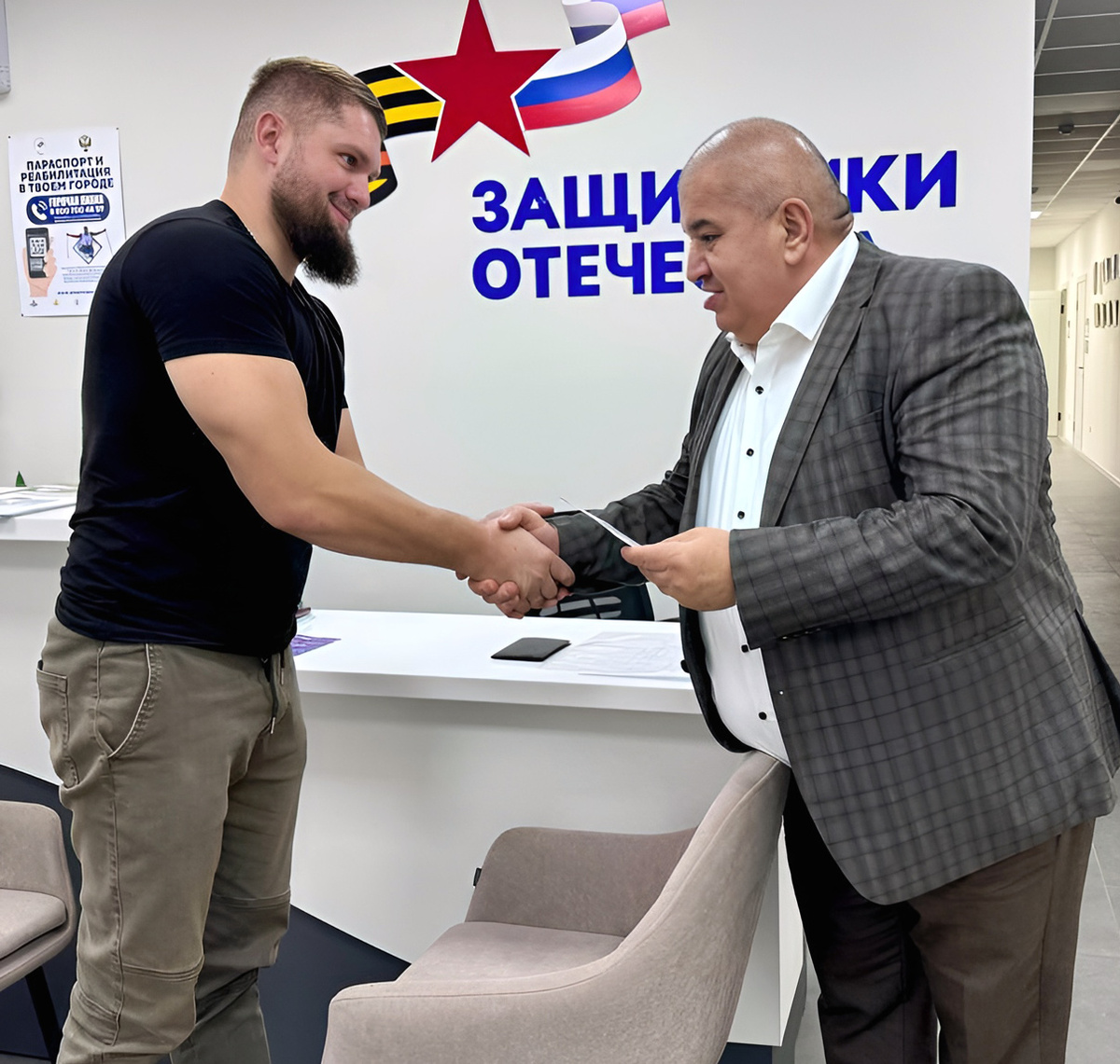 Марат Абазалиев вручает удостоверение ветерана боевых действий демобилизованному участнику СВО