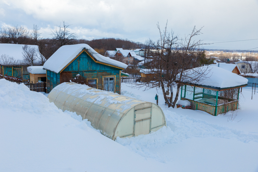 Беседка на дачном участке зимой завалена снегом