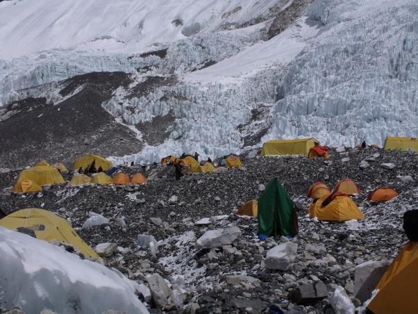 Гораздо более гостеприимный лагерь № 2 на южном склоне Эвереста. На этом фото запечатлена лишь небольшая часть лагеря № 2. Видно, что местность в основном равнинная, альпинисты и шерпы могут свободно передвигаться и общаться, снаряжение сушится на крышах палаток, среди небольших спальных палаток разбросаны большие палатки для приёма пищи и хранения вещей, а также есть палатка-туалет (зелёная).