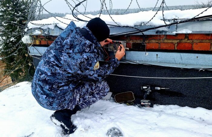 Теперь и мышь не проскочит. Инженер тюремного ведомства устанавливает датчики движения / Фото: пресс-служба ФСИН России