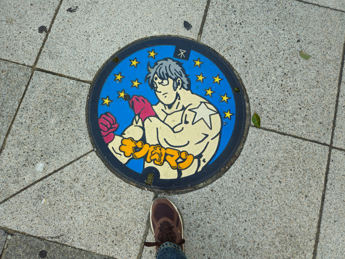 Люк в Осаке с изображением персонажа Тэрримана из манги «Kinnikuman»