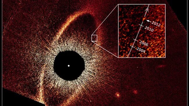 Звезда Фомальгаут в центре на расстояние 133 а.е. от неё пылевое облако и предполагаемая планета Фомальгаут b. ria.ru