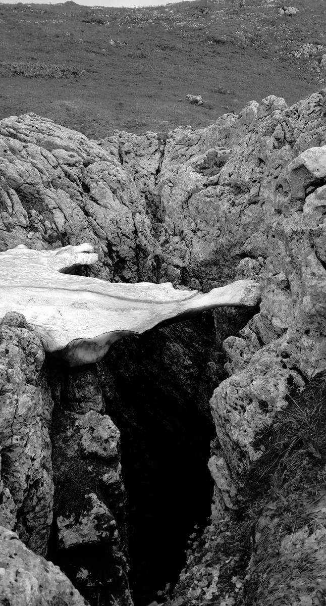 Снежная "крыша" почти растаяла, в глубине карстового провала призывно журчит вода.