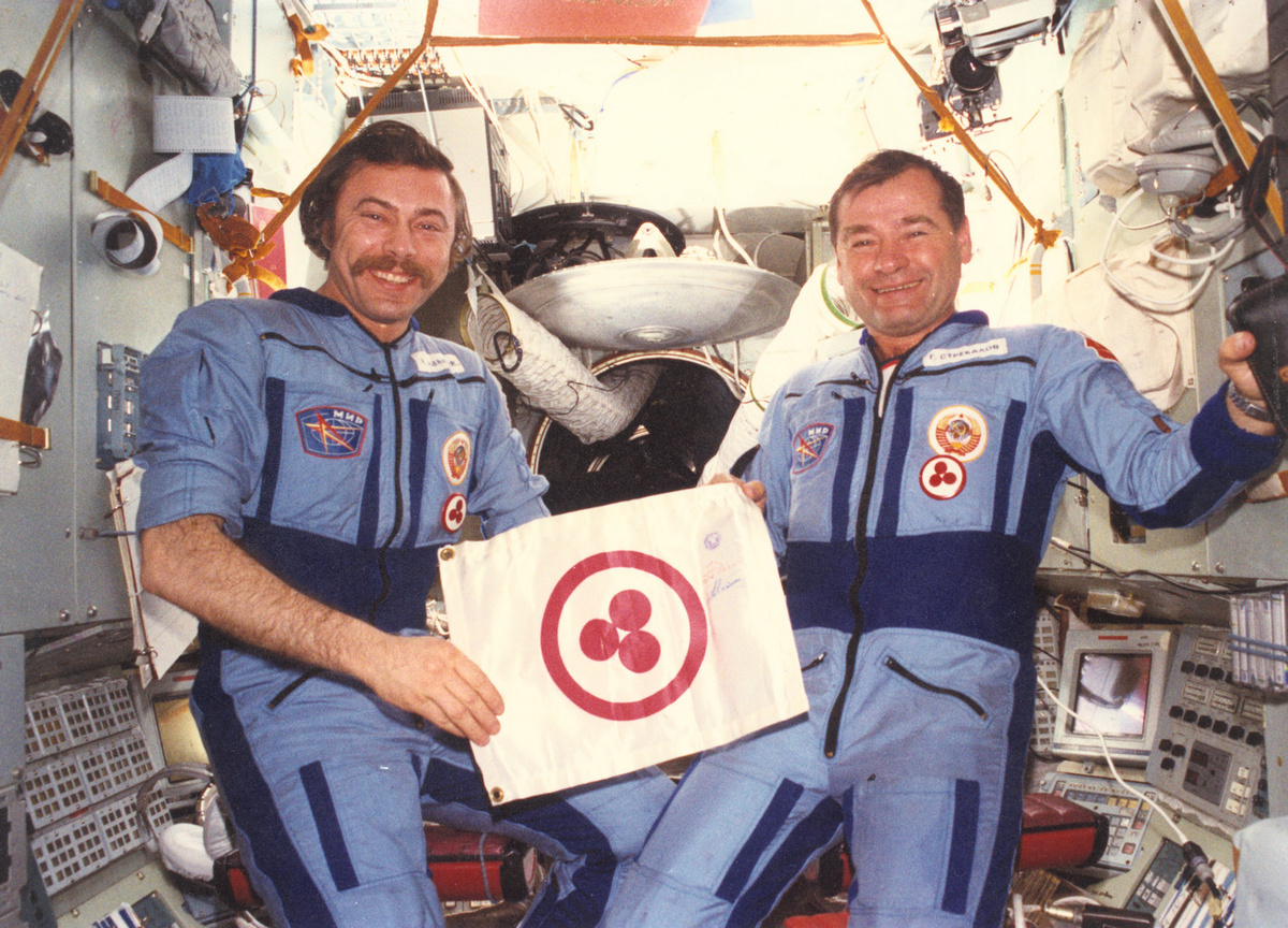 А. Баландин и Г. Стрекалов на борту орбитальной станции "Мир" демонстрируют вымпел "Знамя Мира". 1990 год