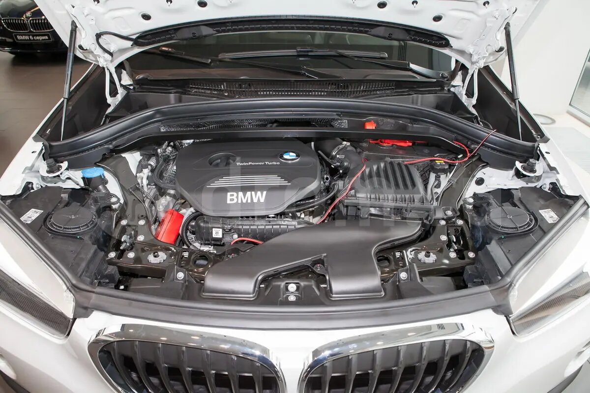 Двигатели BMW X1 F48 простыми словами

В X1 F48 ставят всего три типа моторов:  
1.5 бензин (B38A15), 2.0 дизель (B47D20) и 2.0 бензин (B48A20/B48B20).  
BMW ушла в «даунсайзинг»: маленький объем, турбо и максимум эффективности — но у каждого мотора свой характер.

1.5 бензин B38A15 — «маленький, но живучий»

3‑цилиндровый мотор, базовый для X1.

Плюсы:
- один из самых надежных современных моторов BMW  
- ресурс спокойно за 300 000 км при нормальном обслуживании  
- работает довольно ровно для «тройки» благодаря балансирным валам  

Что бывает:
- вибрации из‑за форсунок (часто лечится чисткой, позже — заменой)  
- плавающие обороты из‑за грязного дросселя/каналов ХХ  
- повышенный расход топлива при глюках датчиков 