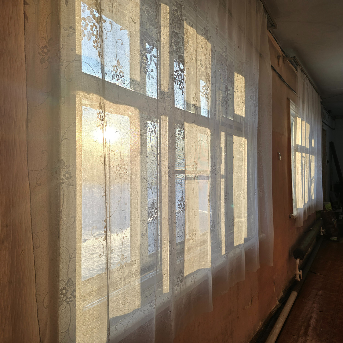 солнечные полосы сквозь тюль коридора