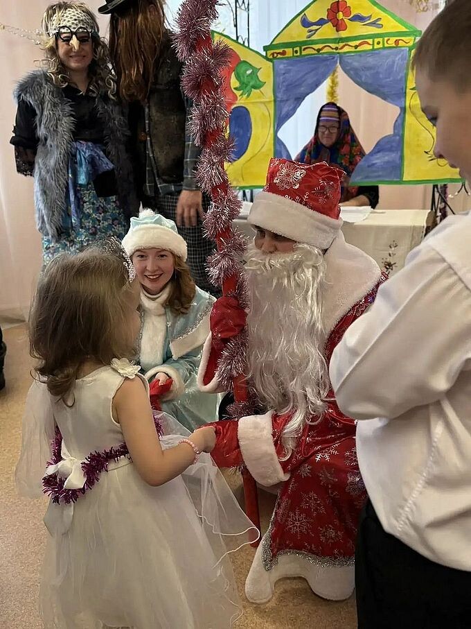 Дед Мороз и Снегурочка расспрашивают девочку, Баба Яга и Леший на заднем плане