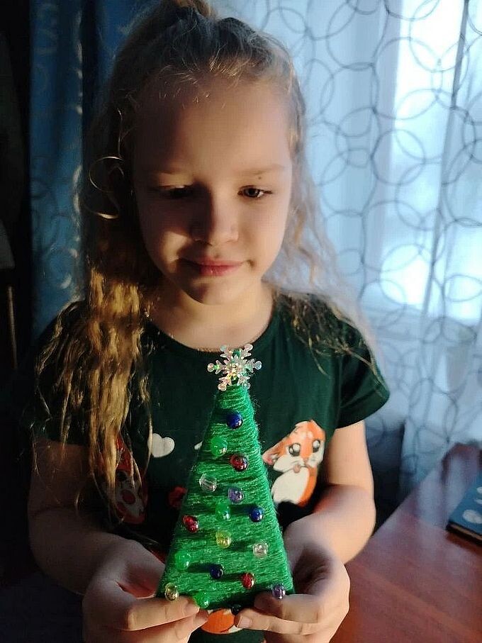 Девочка держит маленькую игрушечную ёлочку