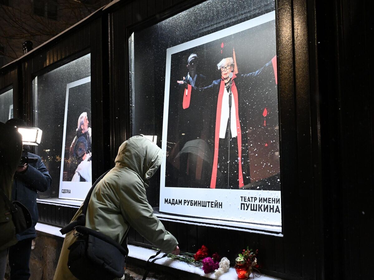    Женщина оставляет цветы у афиши спектакля "Мадам Рубинштейн" в Театре имени Пушкина | © РИА Новости / Екатерина Чеснокова