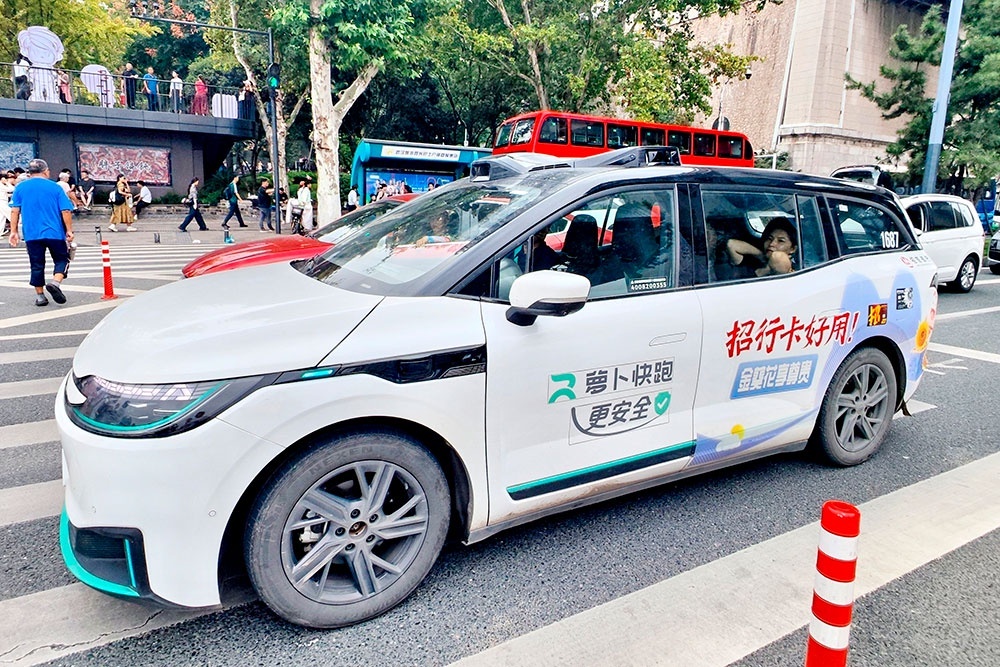    Беспилотный автомобиль Apollo Go, сервиса роботакси компании Baidu, на улицах Уханя, административного центра провинции Хубэй. / Фото: Ли Чанлинь / для China Daily