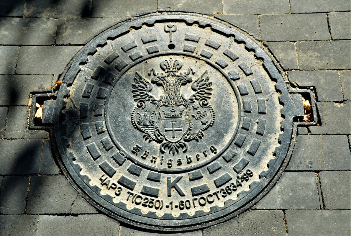 Калининградский люк с надписью Königsberg, российский двуглавый орёл и ГОСТ
