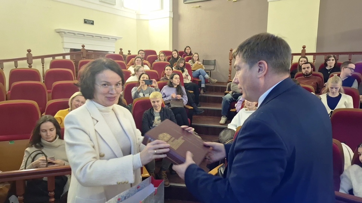 Мария Захарова вручила Сергею Карпищенко монографию, посвященную истории СПбГПМУ.