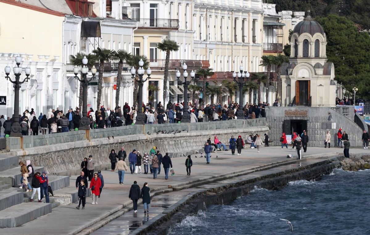 Набережная Ялты в зимний период заполнена отдыхающими.