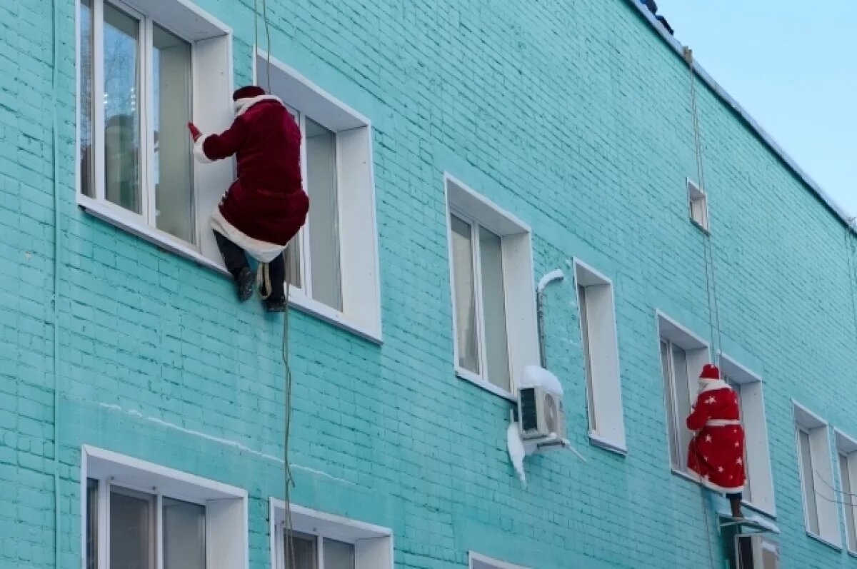    Деды Морозы с помощью альпинистского снаряжения спустились с крыши.