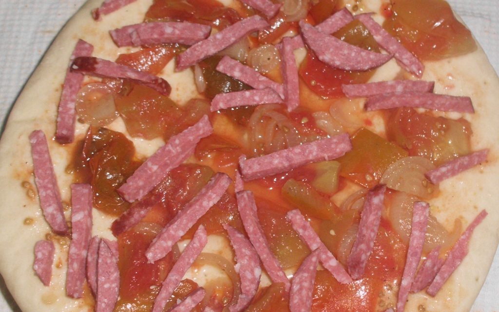 Маринованные помидоры с луком и колбаса соломкой на заготовке для пиццы. Фото автора канала Житейская проза