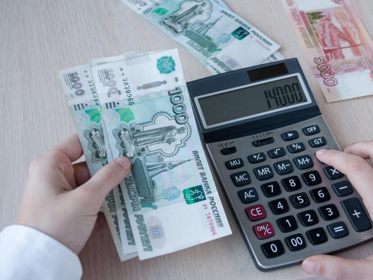    Девушка считает прибыль на калькуляторе | © iStock.com / PROMT8