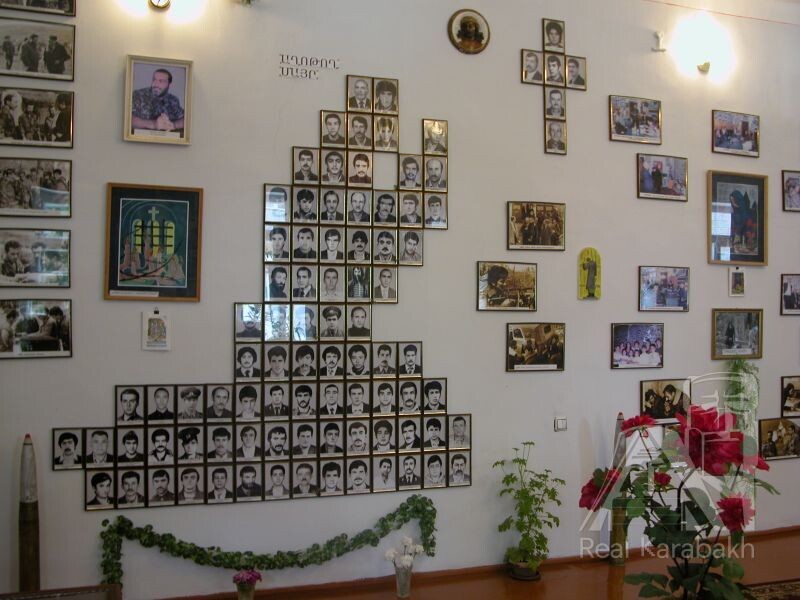 Фотографии пропавших без вести расставлены в образах женщины,  держащей за руку другого своего ребенка (вверху слева), и женщины, на коленях молящейся о возвращении любимого человека (вверху справа).