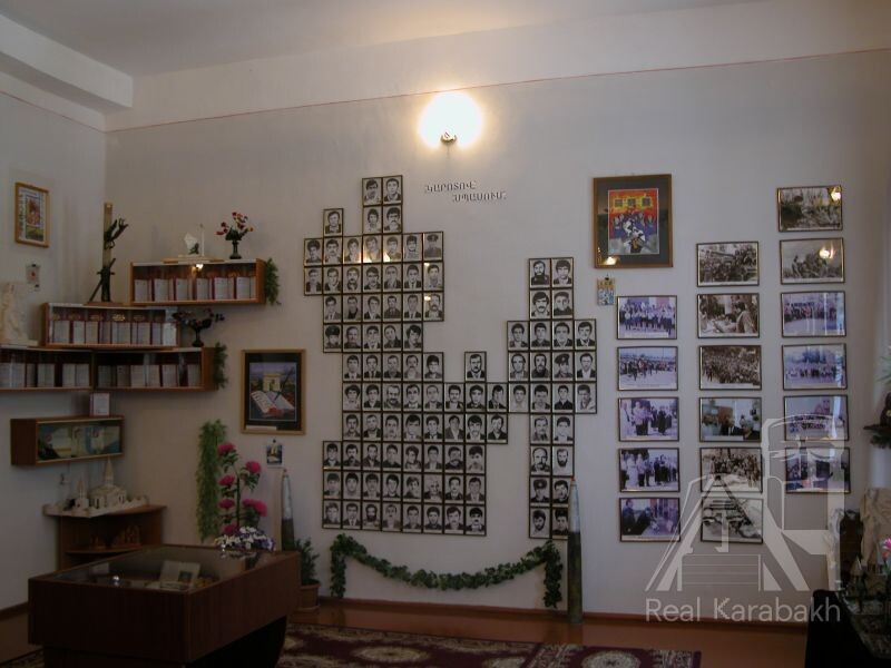 Фотографии пропавших без вести расставлены в образах женщины,  держащей за руку другого своего ребенка (вверху слева), и женщины, на коленях молящейся о возвращении любимого человека (вверху справа).