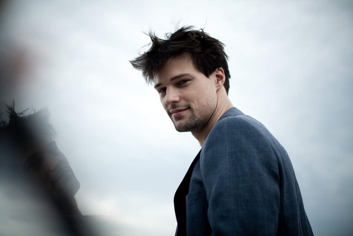 Вчера в Екатеринбурге при полном аншлаге прошла премьера спектакля «Киндер Вилейское». Билеты были распроданы за три месяца. Главную роль играет не местная звезда, а человек, который мог бы сегодня сниматься в Голливуде или отдыхать на Лазурном берегу. Данила Козловский. В 39 лет он — самый востребованный актёр России по версии Forbes, режиссёр, продюсер и создатель уникального культурного моста между театром, кино и регионами. Его называют «актёром будущего», но работает он с классикой. Его лицо знает каждый, но живёт он не в соцсетях, а в репетиционных залах. Как выпускник питерской театральной школы стал главным культурным стратегом своего поколения? Это история о таланте, который предпочел раздавать билеты не на красную дорожку, а в зал на шестой этаж заводского ДК.