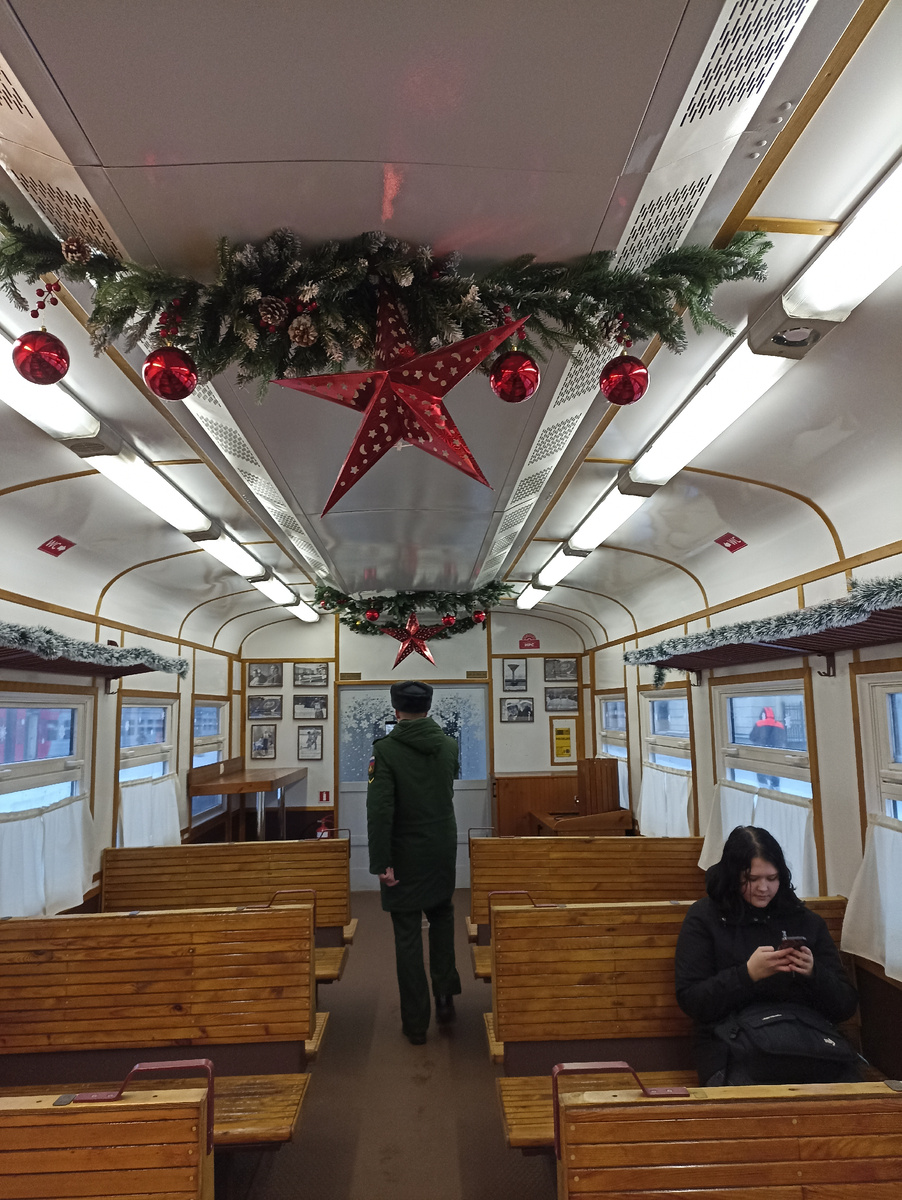 Деревянные сиденья, занавески и старые картинки. Вагон хорошо украшен к Новому году 