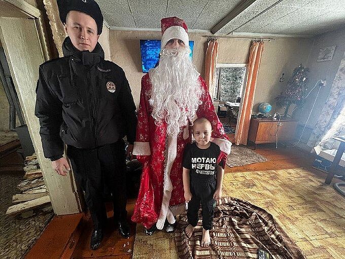Мальчик рядом с сотрудником полиции и полицейским Дедом Морозом