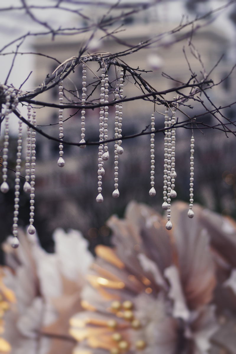 Жемчужные бусы, развешанные вокруг цветов, смотрятся очень гармонично.