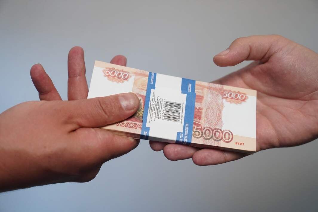 Передача денег. Фото: ИЗВЕСТИЯ/Эдуард Корниенко