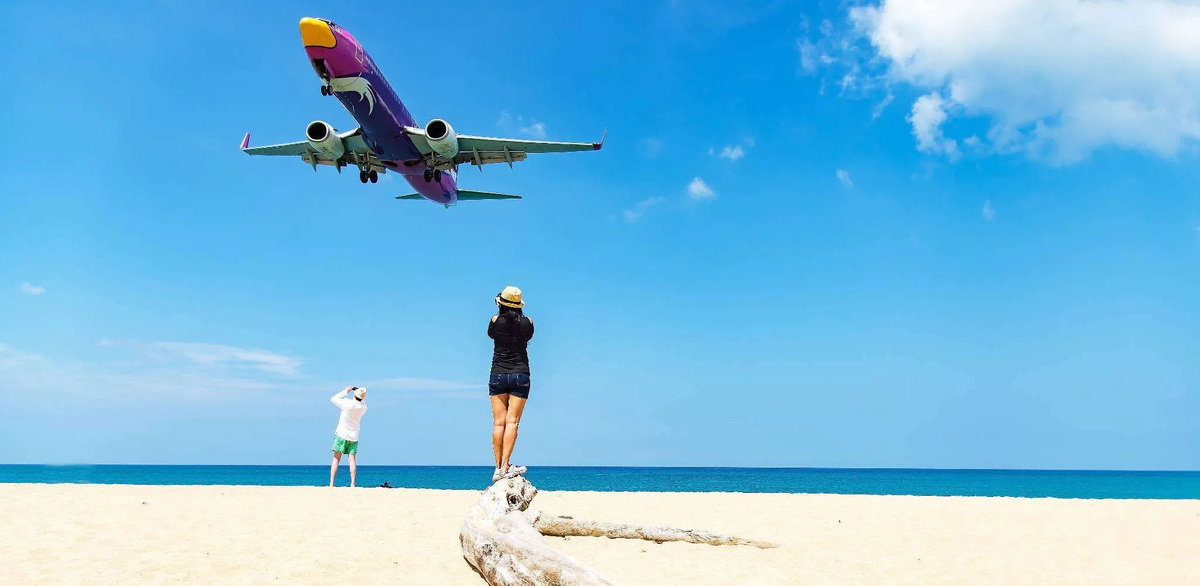 Поймать такой кадр можно только в момент захода самолёта на посадку со стороны моря — пролёт длится всего несколько секунд.