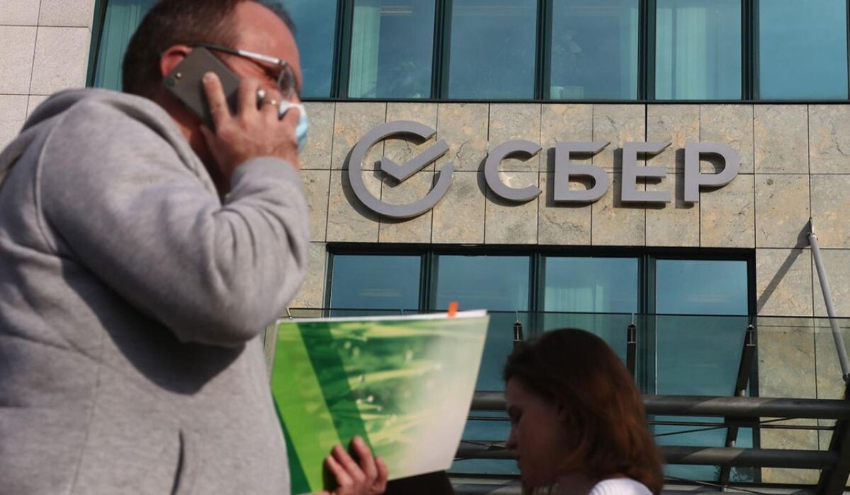     Люди на фоне здания Сбербанка. Источник: rbc.ru Автор фото: Валерий Шарифулин