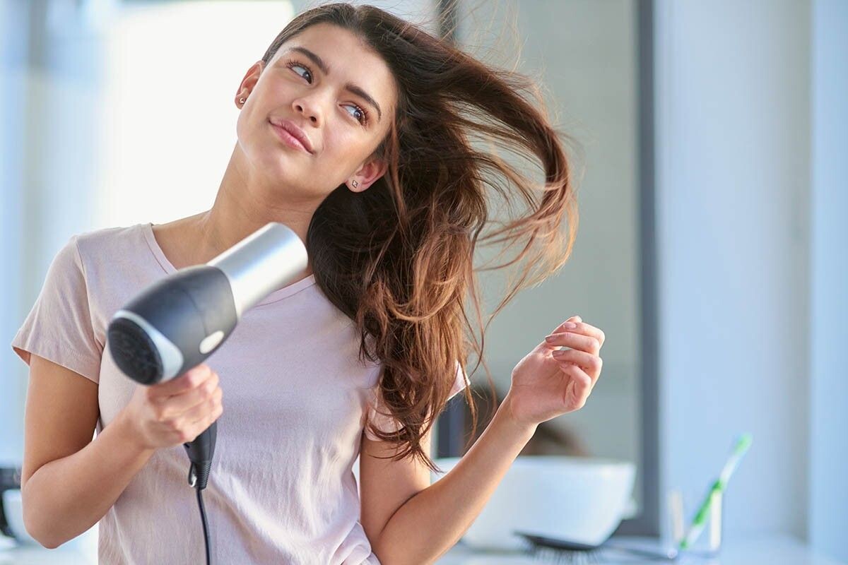Важно правильно подобрать фен, чтобы локоны не пострадали от частых сушек. Источник: PeopleImages / Shutterstock / FOTODOM📷
