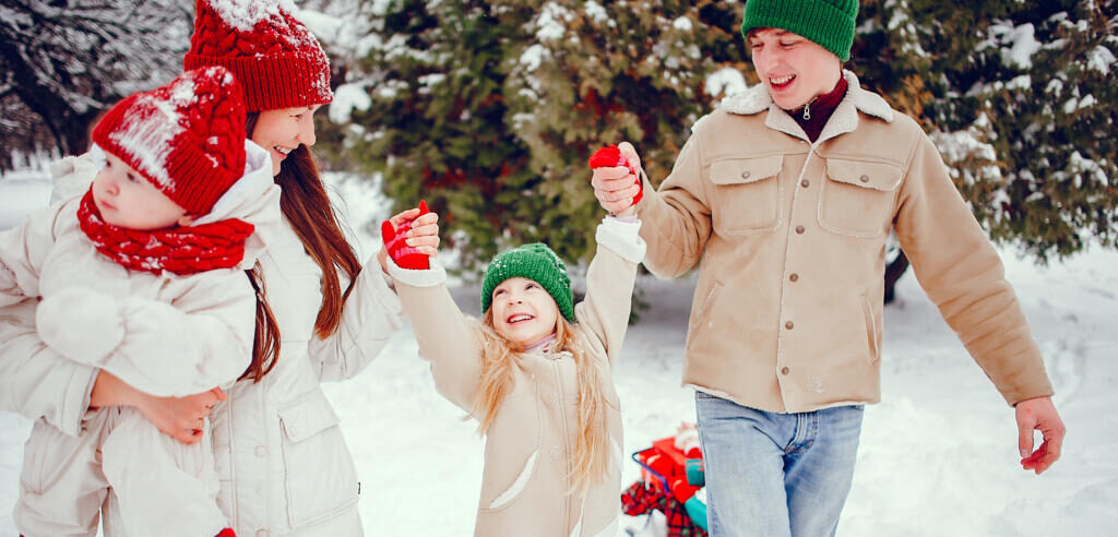    Beautiful mother in a red hat. Family playing in a winter park. Father with children Журналист