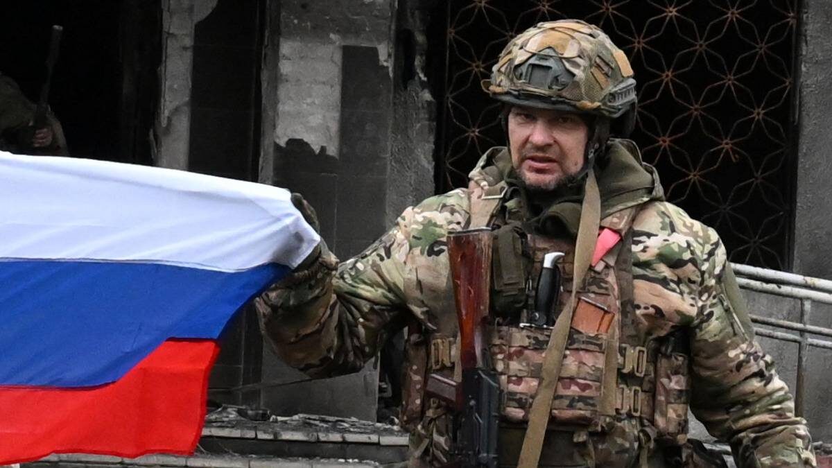    Командир штурмовой роты 506-го гвардейского мотострелкового полка Дмитрий Мишин группировки войск «Центр» развернул флаг России у здания администрации в Красноармейске (ДНР) / Фото: Станислав Красильников / РИА Новости