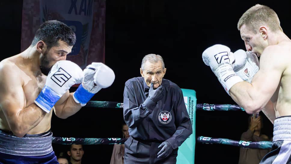 Боксеры Кароматулло Шарипов и Игорь Семернин сходятся в центре ринга перед началом боя, рефери Александр Калинкин контролирует эпизод.📷Фото: Егор Снетков / Коммерсантъ